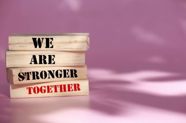 Birlikteyken daha güçlüyüz. Kelimelerle tahta bloklar Birlikteyken daha güçlüyüz. Güzel pembe arka plan. Birlikteyken daha güçlüyüz. Boşluğu kopyala.