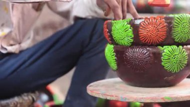 Yetenekli bir işçi ya da işçi canlı renkler ve süngerle kilden bir tencereyi boyar, geleneksel zanaat ve sanatsal teknikleri el yapımı bir çömlek dekorasyonu sürecinde sergiler. 4k Video 50 fps