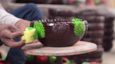 Yetenekli bir işçi ya da işçi canlı renkler ve süngerle kilden bir tencereyi boyar, geleneksel zanaat ve sanatsal teknikleri el yapımı bir çömlek dekorasyonu sürecinde sergiler. 4k Video 50 fps