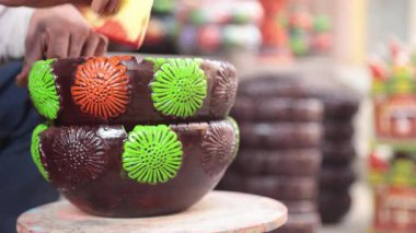 Yetenekli bir işçi ya da işçi canlı renkler ve süngerle kilden bir tencereyi boyar, geleneksel zanaat ve sanatsal teknikleri el yapımı bir çömlek dekorasyonu sürecinde sergiler. 4k Video 50 fps