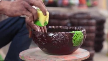 Yetenekli bir işçi ya da işçi canlı renkler ve süngerle kilden bir tencereyi boyar, geleneksel zanaat ve sanatsal teknikleri el yapımı bir çömlek dekorasyonu sürecinde sergiler. 4k Video 50 fps
