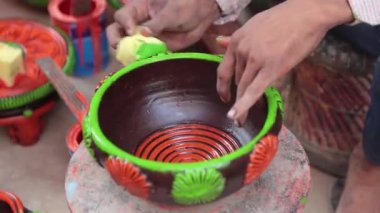 Yetenekli bir işçi ya da işçi canlı renkler ve süngerle kilden bir tencereyi boyar, geleneksel zanaat ve sanatsal teknikleri el yapımı bir çömlek dekorasyonu sürecinde sergiler. 4k Video 50 fps