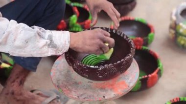 Yetenekli bir işçi ya da işçi canlı renkler ve süngerle kilden bir tencereyi boyar, geleneksel zanaat ve sanatsal teknikleri el yapımı bir çömlek dekorasyonu sürecinde sergiler. 4k Video 50 fps