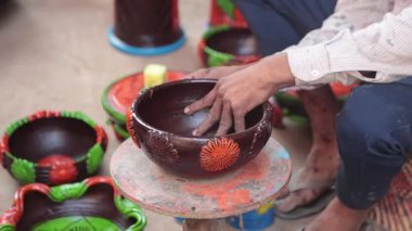 Yetenekli bir işçi ya da işçi canlı renkler ve süngerle kilden bir tencereyi boyar, geleneksel zanaat ve sanatsal teknikleri el yapımı bir çömlek dekorasyonu sürecinde sergiler. 4k Video 50 fps