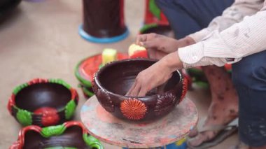 Yetenekli bir işçi ya da işçi canlı renkler ve süngerle kilden bir tencereyi boyar, geleneksel zanaat ve sanatsal teknikleri el yapımı bir çömlek dekorasyonu sürecinde sergiler. 4k Video 50 fps
