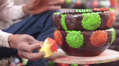 Yetenekli bir işçi ya da işçi canlı renkler ve süngerle kilden bir tencereyi boyar, geleneksel zanaat ve sanatsal teknikleri el yapımı bir çömlek dekorasyonu sürecinde sergiler. 4k Video 50 fps