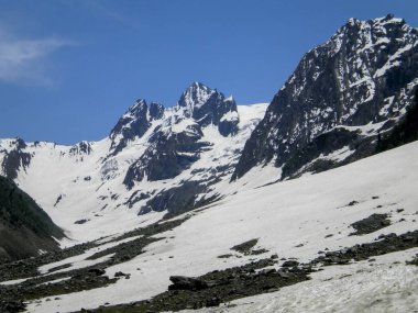 Pahalgam, Kaşmir 'de açık mavi gökyüzü üzerinde kısmi kar yağışı ile kaplı dağ sırası