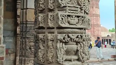 Kutub Minar-New Delhi - 21 Haziran 2025 'te Hindistan' ın başkenti Yeni Delhi 'de yaz aylarında yağmurlu bir günde ziyaretçileri ağırlayan bir UNESCO Dünya Mirası sitesi olan Kutub Minar kompleksi içinde İslami oyma sahip bir sütundan çekilen fotoğraf. 