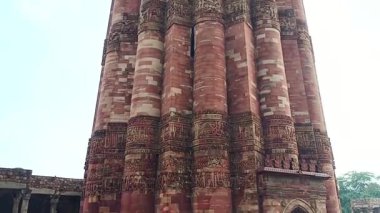 Qutub Minar-New Delhi - Hindistan - 21 Haziran, 2025-yakın çekim Qutub Minar üssü. İnsanlar yağmurlu bir günde anıtı ziyaret ediyorlar.