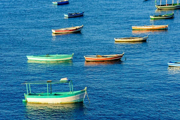 Rustic wooden fishing boats in the sea of the city of Salvador in Bahia