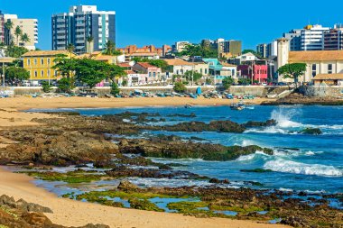 Praia do Rio Vermelho which is known as the bohemian neighborhood of the city of Salvador in Bahia with its rocks, boats and houses on a sunny summer day