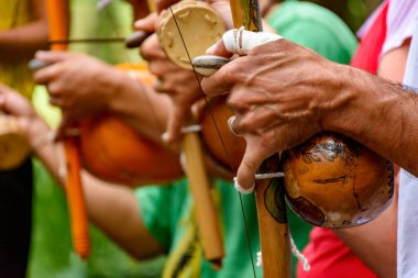 Brezilya sokaklarında Capoeira performansı sırasında Berimbau adı verilen bir müzik enstrümanı çalan bir müzisyenin elleri