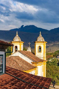 Minas Gerais 'deki Ouro Preto şehrinin arka planında dağlar olan tarihi kilise kuleleri.
