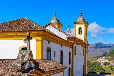 Minas Gerais 'deki Preto şehrinin arka planında dağlar olan renkli barok kilisesi.