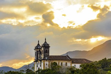 Tepedeki eski kilise ve Minas Gerais 'deki Ouro Preto şehrindeki bitki örtüsü arasında.