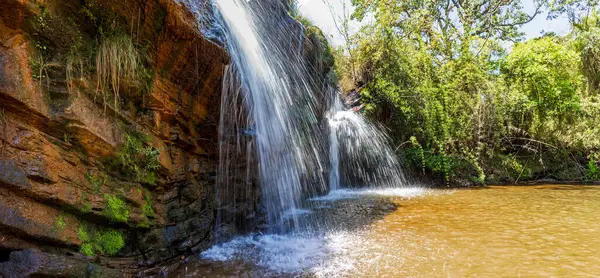 Beautiful waterfall among the rocks and forest in the Muaimii environmental reserve in the state of Minas Gerais on a sunny day