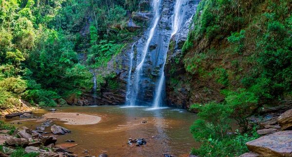 Waterfall flowing into a water well in the middle of the forest in the state of Minas Gerais, Brazil