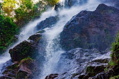 Kayaların ve ormanın içinden akan su Brezilya 'nın Minas Gerais şehrinde güzel bir şelale oluşturuyor.