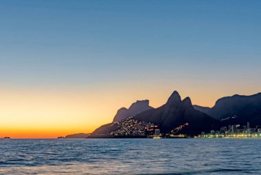 Rio de Janeiro 'daki Ipanema plajında gün batımında aydınlatılan binalar