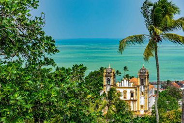 Pernambuco 'daki Olinda şehrinde bitki örtüsü ve deniz arasındaki antik barok kilisesi.