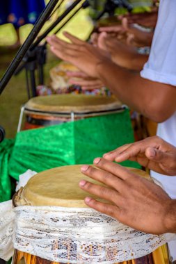 Brezilya 'da düzenlenen bir Umbanda dini ayini sırasında kumaşla süslenmiş birkaç atabak davulu çalan eller