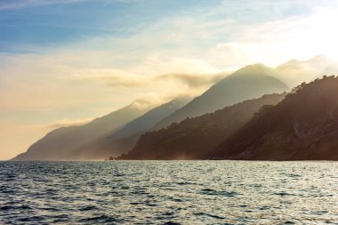 Ilhabela adasının dağları ve ormanları gün batımında denize kavuşuyor.