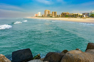 Barra da Tijuca plajı, Rio de Janeiro şehrinde gün doğumunda dalgakıran rıhtımından görüldü.