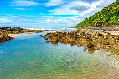 Brezilya 'nın Bahia eyaletinin güney sahilinde ıssız bir sahilde kayalar ve su.