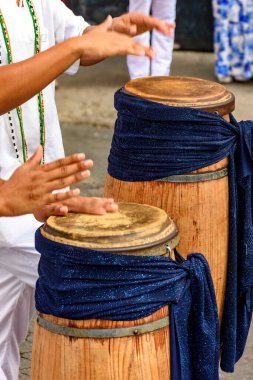Umbanda şenlikleri sırasında Brezilya sokaklarında geleneksel atabaklara sahip iki kişi çalınıyor