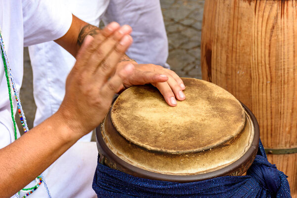 Hands playing traditional African atabaque drums being played on the streets of Brazil during Umbanda religious festivities