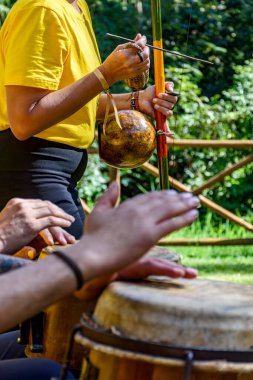 Brezilya capoeira 'sında berimbau ve atabaque oynayan bir grup insan