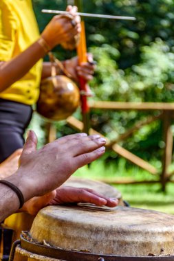 Brezilya Capoeira 'sında berimbau ve atabak çalan müzisyenlerin elleri