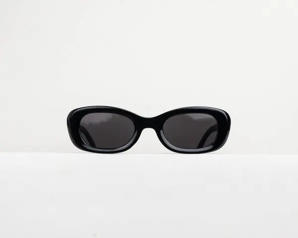 Beyaz arka planda siyah güneş gözlüğü. Şık ve havalı görünüyor.
