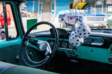 Aynada tüylü zarlar olan mavi bir arabanın iç görünümü