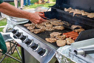 Bir adam et hazırlıyor ve ızgara yapıyor..