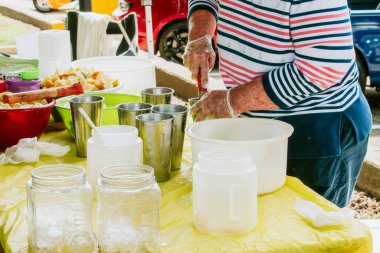 Limonata yapmak için limon ve şeker ezen bir kadın.