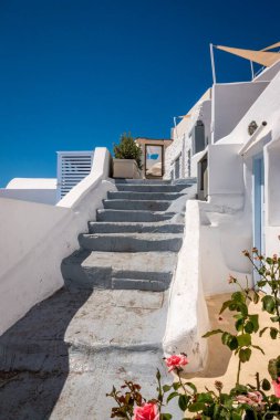 Santorini 'den gelen bu büyüleyici görüntüde, bir tepenin tepesine tünemiş büyüleyici bir çerçeve kapısına doğru bir dizi adım zarif bir şekilde yükseliyor.. 