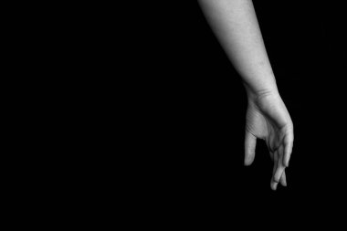 Siyah-beyaz kadın elleri ve koyu arka planda kapalı parmakları ile metin için kopyasal alan