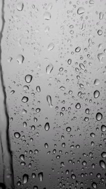 Pencere camından düşen yağmur damlaları. Gri tonlarda yağmur damlalarının soyut arkaplanı. Yüksek kalite 4k görüntü
