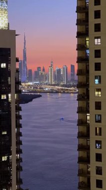 Gün batımında Dubai şehir merkezinin gökdelenler arasında görülebilen Dubai Kanalı 'nın yüksek görünümü. 6 Ekim 2024, Dubai, BAE. Yüksek kaliteli FullHD görüntüler