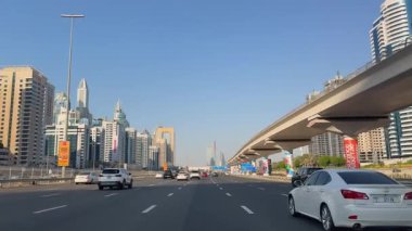 Dubai Marina 'daki Sheikh Zayed Yolu boyunca giderken araba penceresinden manzara, şehir manzarası ve çarpıcı bir ufuk çizgisi. 2 Ekim 2024, Dubai, BAE. Yüksek kalite 4k görüntü