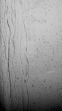 Pencere camından düşen yağmur damlaları. Gri tonlarda yağmur damlalarının soyut arkaplanı. Yüksek kalite 4k görüntü