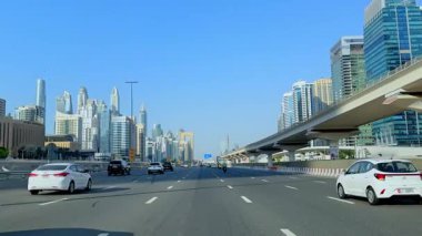 Dubai Marina 'daki Sheikh Zayed Yolu boyunca giderken araba penceresinden manzara, şehir manzarası ve çarpıcı bir ufuk çizgisi. 2 Ekim 2024, Dubai, BAE. Yüksek kalite 4k görüntü