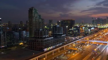 Dubai, BAE - 31 Ekim 2023: Gün batımında Sheikh Zayed Yolu ve Dubai Metro hattı. İnternet şehri bölgesi. Arka planda gökdelenler. Yüksek kalite 4k görüntü