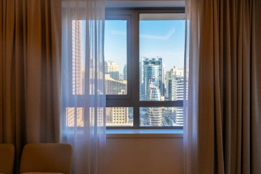 Dubai, Birleşik Arap Emirlikleri gibi modern binalarla yatak odası penceresinden şehir manzarasına bakmak. Yüksek kalite fotoğraf