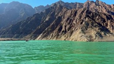 Hatta Barajı gölü ve Hajar Dağları 'nın Dubai' deki güzel manzarası, Birleşik Arap Emirlikleri, engebeli dağ zirveleri ve berrak gökyüzü ile çevrili sakin suları sergiliyor.