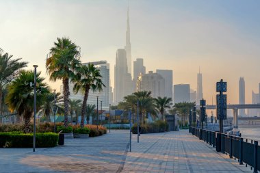  Dubai Tasarım Bölgesi 'ndeki güzel rıhtım güvertesi Dubai silueti ve Burj Halife üzerinde puslu bir günbatımı ile. Yüksek kalite fotoğraf