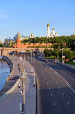 Yazın erken saatlerinde Moskova Nehri, Kremlin kuleleri ve sakin güneş ışığı ve sakin şehir atmosferiyle şehrin güzelliğini yansıtan sessiz setin manzarası. 10 Temmuz 2024, Moskova, Rusya 