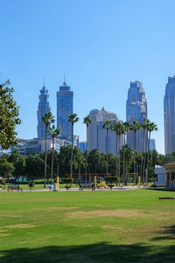 Dubai 'nin merkezinde şehir merkezinin gökdelenlerini gören yeşil bir park. İşe ara vermek için harika bir yer.
