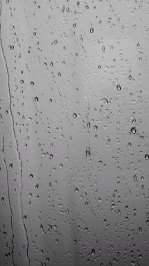 Pencere camından düşen yağmur damlaları. Gri tonlarda yağmur damlalarının soyut arkaplanı. Yüksek kalite 4k görüntü